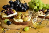 Bruschetta with Greek traditional anthotyro cheese, grape, molasses and walnuts